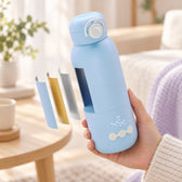 Hand houdt de Lunae flessenwarmer vast met een illustratieve doorsnede van de binnenlagen